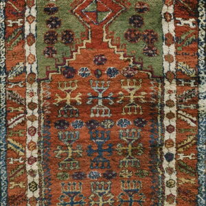 High-pile rug with geometric patterns, featuring a green field within a rust and blue stepped arch design.