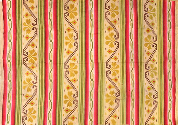 Multicolor flat woven rug featuring vertical bands of red, green, beige, and yellow geometric floral patterns.