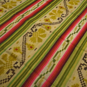 Brightly striped rug in pink, red, and green with beige sections showcasing geometric olive floral patterns.