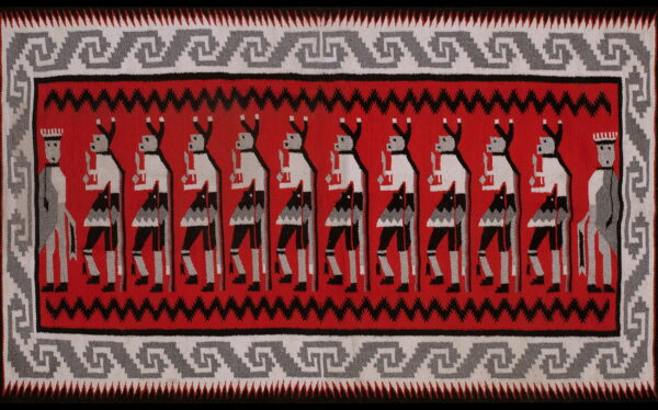 Red, black, and gray flatweave rug with a row of stylized figures and geometric scrollwork borders.