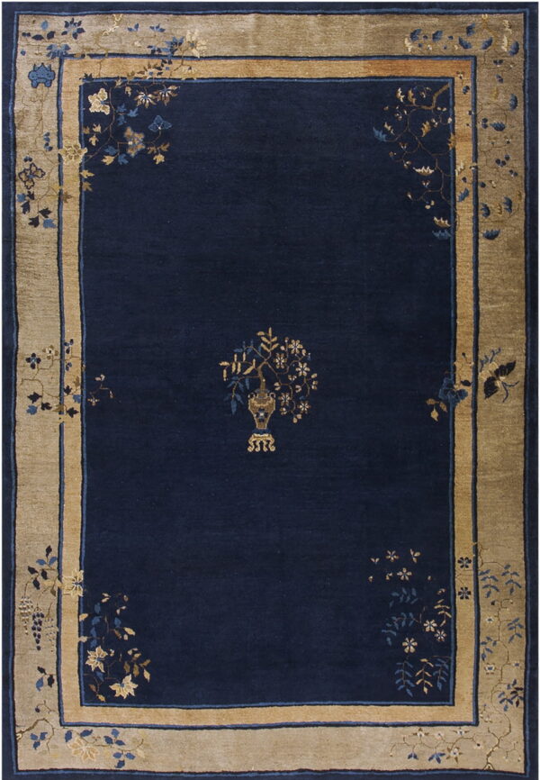 Navy rug with a central vase design and a wide tan border of blue and gold florals.
