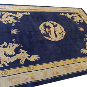 High-pile navy rug featuring yellow dragon motifs centered within gold and ivory patterned borders.