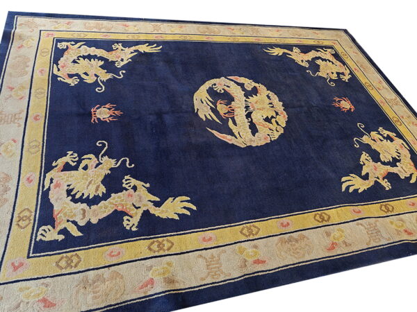 High-pile navy rug featuring yellow dragon motifs centered within gold and ivory patterned borders.