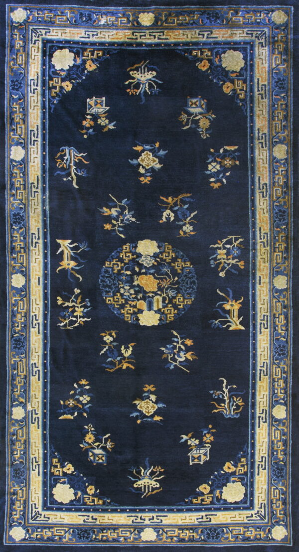 Dark blue rug with stylized yellow and blue botanical motifs and intricate yellow and blue borders.