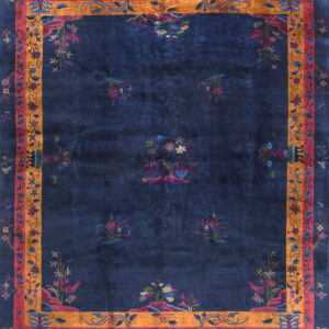 Navy blue rug with multicolored stylized botanicals and a wide gold and rose border.