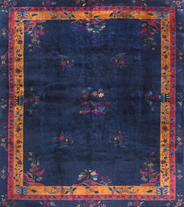 Navy blue rug with multicolored stylized botanicals and a wide gold and rose border.