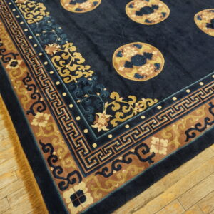 Dark blue rug featuring tan medallions and a wide, multi-colored border on rustic wood planks.