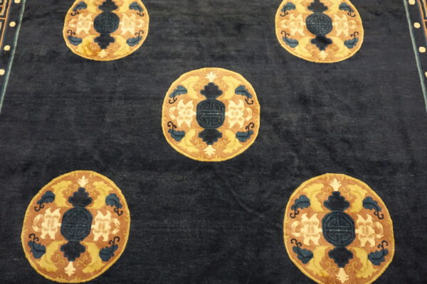 Dark blue rug field featuring five repeating round medallions patterned in gold, brown, and dark blue.