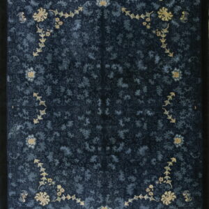 Dark navy blue rug with dense tone-on-tone scrolling florals accented by bright pale yellow floral chains.