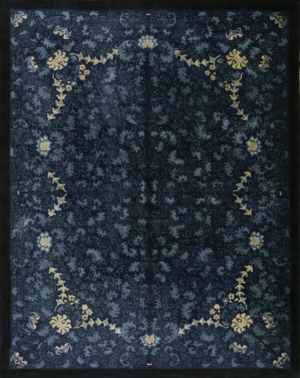 Dark navy blue rug with dense tone-on-tone scrolling florals accented by bright pale yellow floral chains.