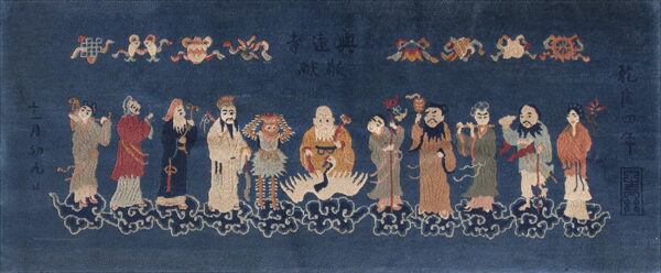 Deep blue rug featuring twelve multicolored figures standing on clouds, flanked by text and ornaments.