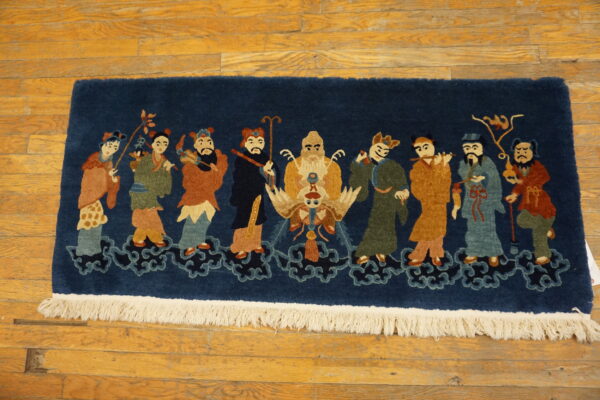 Plush navy rug depicting colorful figures on clouds, visible on light brown wood plank flooring.