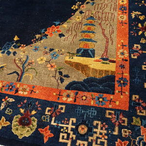 Detailed navy rug corner showing a pagoda scene, flowers, and multi-colored geometric borders.