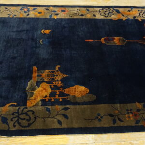 Plush navy blue rug with a taupe border and gold scenic patterns on light wood flooring.