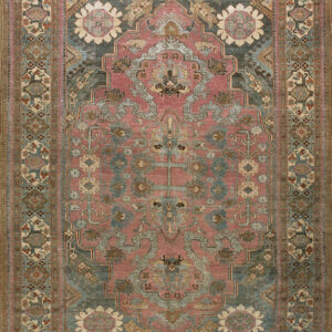 Low pile rug with a dusty rose field, muted blue-green medallion, and intricate floral and geometric patterns.