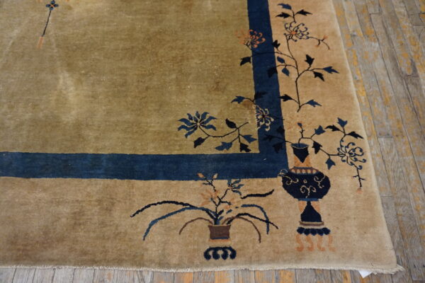 Beige high-pile rug border with navy blue floral vases on worn wooden floorboards.