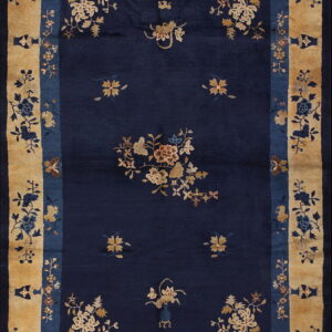 Navy blue rug with scattered tan floral designs and an intricate wide border of gold, blue, and vases.
