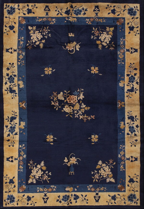 Navy blue rug with scattered tan floral designs and an intricate wide border of gold, blue, and vases.
