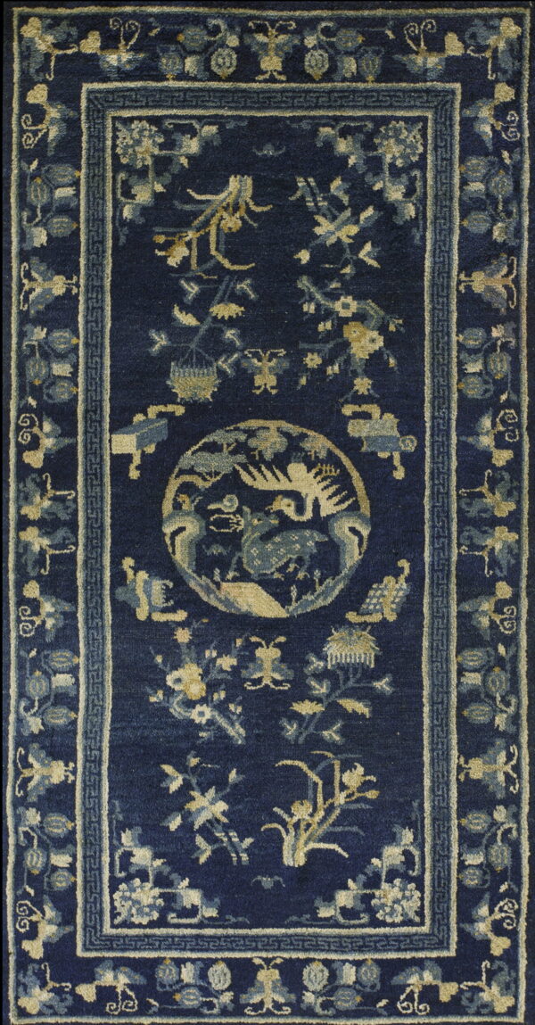 Deep navy blue rug featuring a central medallion and scattered traditional floral and animal motifs in beige and light blue.