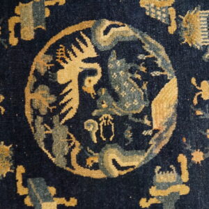 Navy blue rug detail showing an intricate central medallion pattern in gold and muted blue.