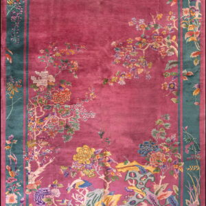 Ornate high-pile magenta rug featuring flowering trees, birds, and a wide teal and pink border.