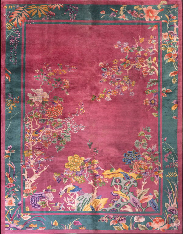 Ornate high-pile magenta rug featuring flowering trees, birds, and a wide teal and pink border.