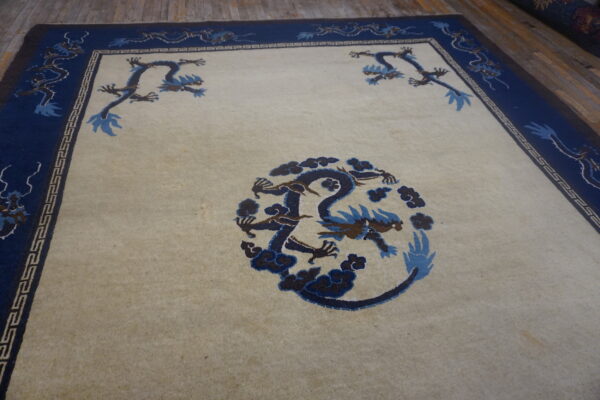 Cream rug with a blue dragon medallion and blue border featuring stylized dragons.