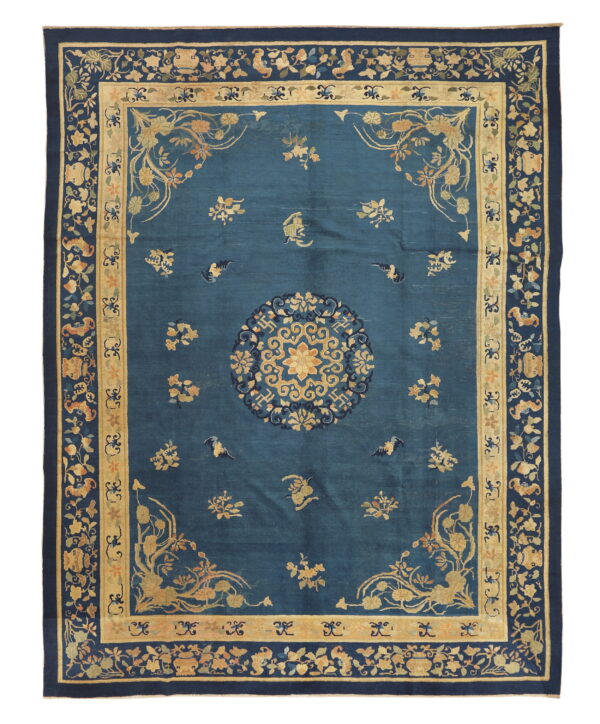 Rectangular dark blue rug featuring a central gold floral medallion and complex multi-layered vine and flower borders.