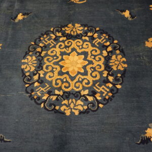 Navy blue rug with a large circular gold and dark blue floral and scrollwork medallion design.