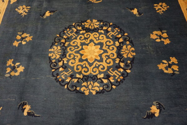 Navy blue rug with a large circular gold and dark blue floral and scrollwork medallion design.