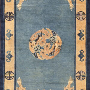 Blue rug with central orange medallion, tan dragon corners, and dark navy border motifs.