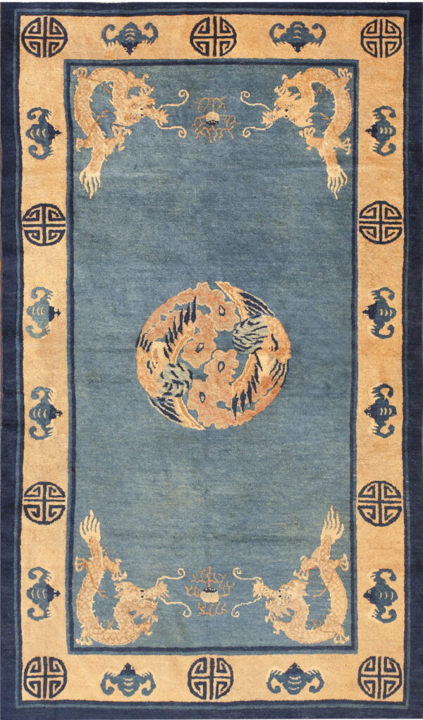 Blue rug with central orange medallion, tan dragon corners, and dark navy border motifs.