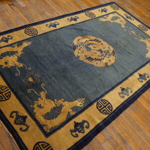 Teal rug with central medallion and gold dragon borders rests on plank wood floor.