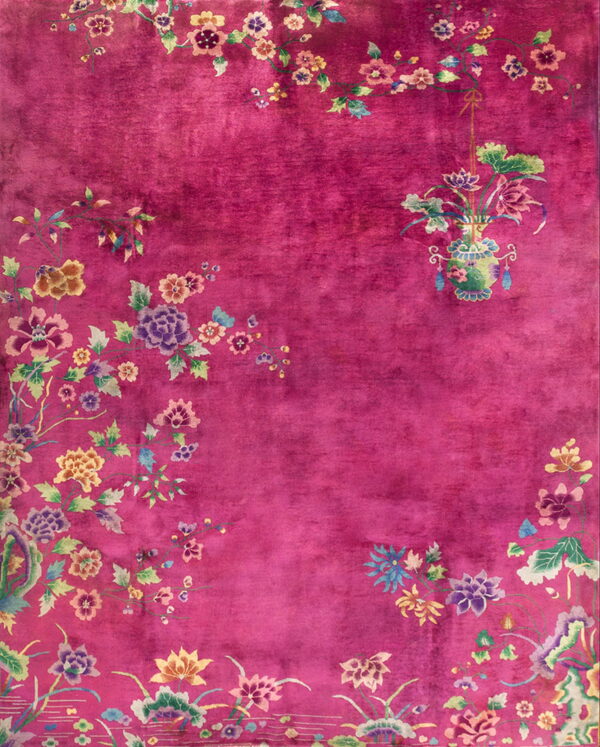 Deep magenta rug with multicolored floral borders and a distinct hanging vase motif on the right.