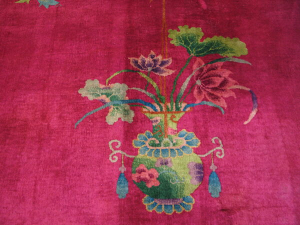 Vibrant magenta rug displaying a colorful floral bouquet in a green and blue decorative vase.