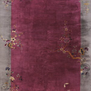 A velvety magenta rug with a wide gray border decorated with multicolor floral and butterfly patterns.