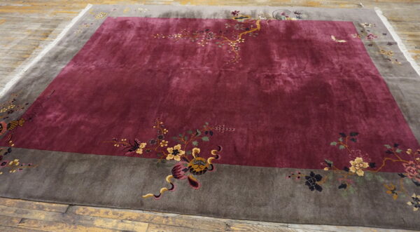 Deep reddish-purple rug with a contrasting gray border featuring multicolored floral and creature motifs.