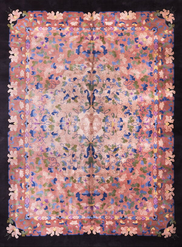 Rosy pink field rug with dense blue and green floral designs, framed by a thick solid black border.