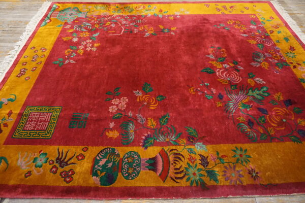 High pile magenta rug featuring complex multicolored botanical patterns and symbols within a gold border on wood flooring.