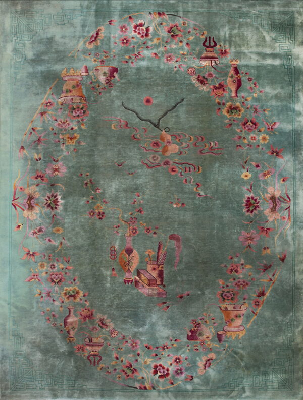 Velvety teal rug displaying pink and red florals, vines, and symbolic vessels within a central oval.