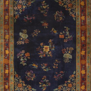 Navy rug with scattered multicolored floral bouquets and a wide, detailed border in rust, gold, and teal.