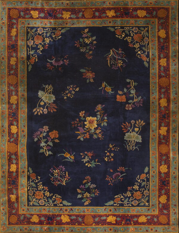 Navy rug with scattered multicolored floral bouquets and a wide, detailed border in rust, gold, and teal.