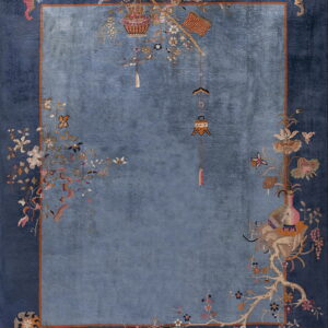 Plush deep blue rug featuring a lighter blue center and a border with detailed pink and gold botanical images.