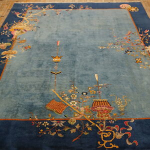 Light blue and indigo rug featuring ornate motifs and symbols rests on light brown plank flooring.