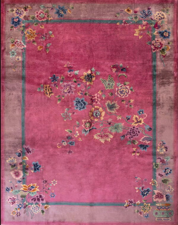 High-pile fuchsia rug with an ornate multicolored floral design and a wide dusty rose border.