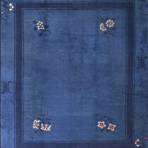 Deep blue high-pile rug with dark borders, accented by stylized cream and pink floral motifs.