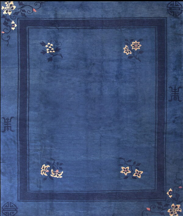 Deep blue high-pile rug with dark borders, accented by stylized cream and pink floral motifs.