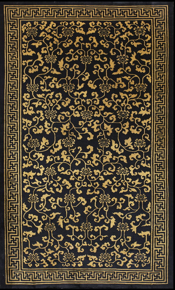Black rug with an all-over golden floral vine pattern and a geometric greek key border.