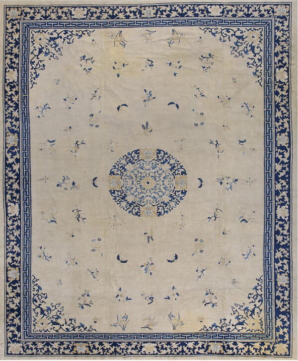 Ivory rug with scattered blue floral motifs, a central medallion, and a wide navy border.