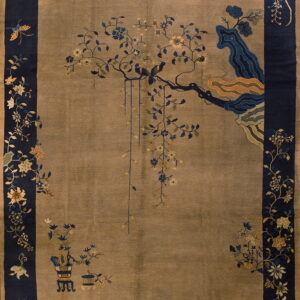 Taupe rug with a wide navy blue border and intricate pattern featuring birds on a flowering branch.